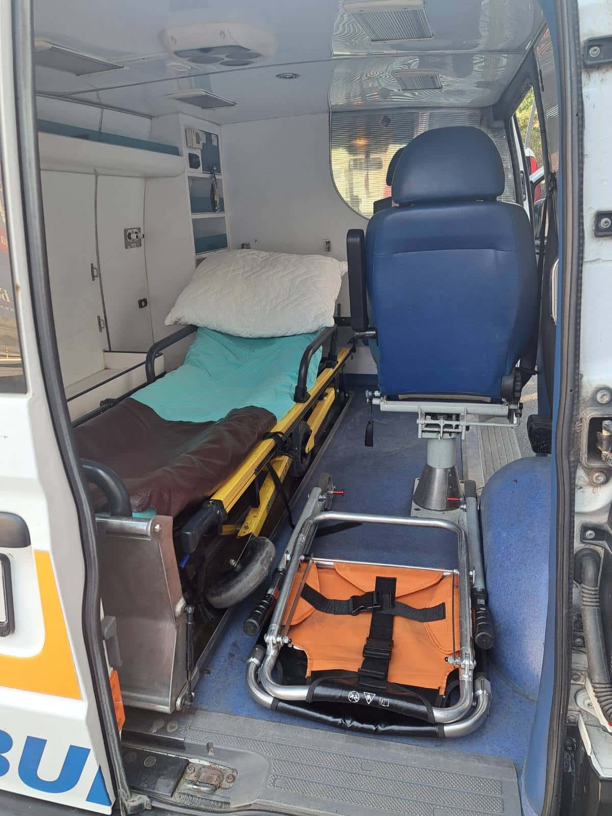Unutrašnjost sanitetskog vozila sa nosilima i pratećim sedištem za pacijenta